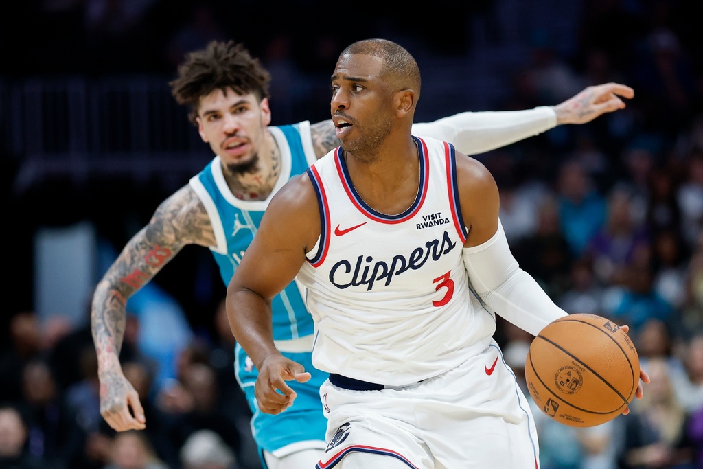 Los Angeles Clippers guard Chris Paul (3) pushes the ball up court ahead of Charlotte Hornets guard LaMelo Ball during the first half of an NBA basketball game in Charlotte, N.C., Saturday, Nov. 22, 2025. (AP Photo/Nell Redmond)