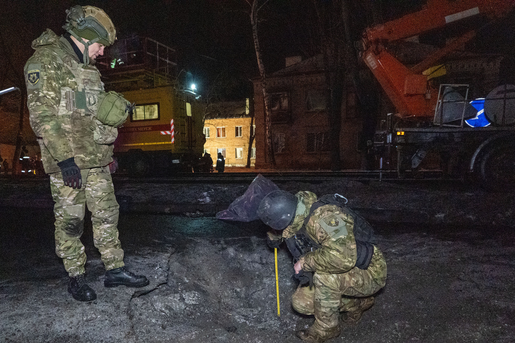 Police officers inspect inspect the site of the Russian airstrike in Kharkiv, Ukraine, Friday, Dec. 26, 2025. (AP Photo/Andrii Marienko)