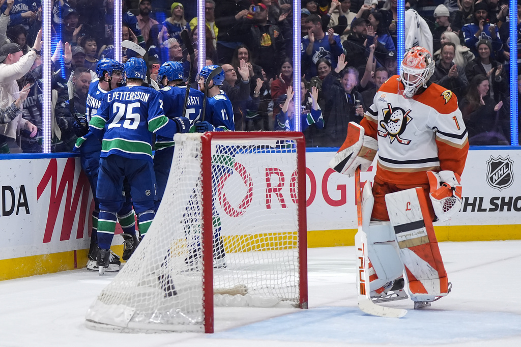 Vancouver Canucks' Drew O'Connor, back left to right, Elias Pettersson, Aatu Raty, Filip Hronek and Jake DeBrusk, hidden, back center, celebrate O'Connor's goal against Anaheim Ducks goalie Lukas Dostal (1) during the third period of an NHL hockey game, in Vancouver, on Thursday, Jan. 29, 2026. (Darryl Dyck/The Canadian Press via AP)