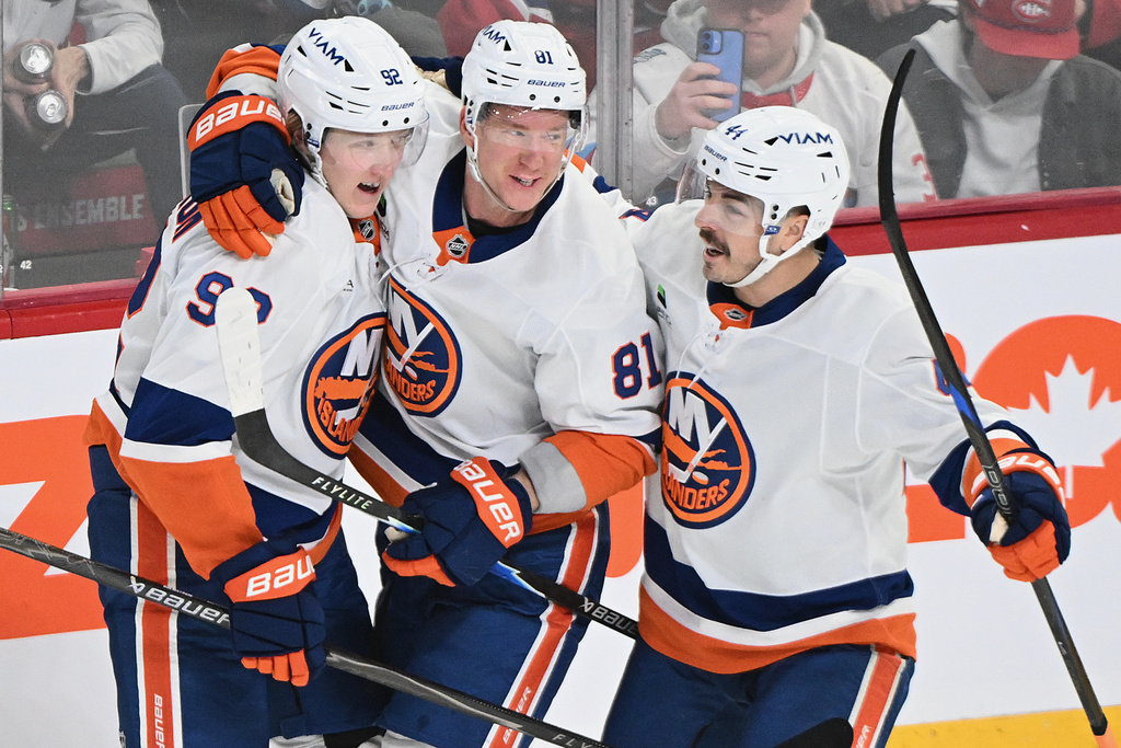 New York Islanders' Simon Holmstrom (92) celebrates with teammates Ondrej Palat (81) and Jean-Gabriel Pageau (44) after scoring against the Montreal Canadiens during the first period of an NHL hockey game in Montreal, Saturday, March 21, 2026. (Graham Hughes/The Canadian Press via AP)