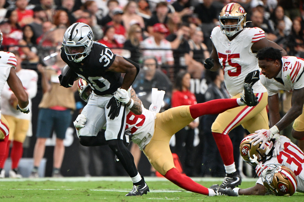 San Francisco 49ers safety Ashtyn Davis (29) tackles Las Vegas Raiders running back Mike Washington Jr. (30) as San Francisco 49ers linebacker Jaden Dugger (53) loses his helmet during the first half of an NFL preseason football game, Thursday, Aug. 27, 2026}, in Las Vegas. (AP Photo/David Becker)
