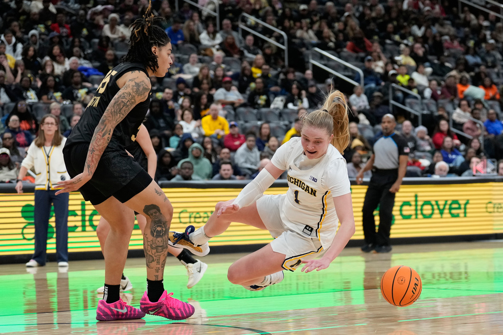 Michigan's Olivia Olson, right, goes to the ground as she is guarded by Vanderbilt's Sacha Washington during the second half of an NCAA women's college basketball game in Newark, N.J., Monday, Jan. 19, 2026. (AP Photo/Seth Wenig)