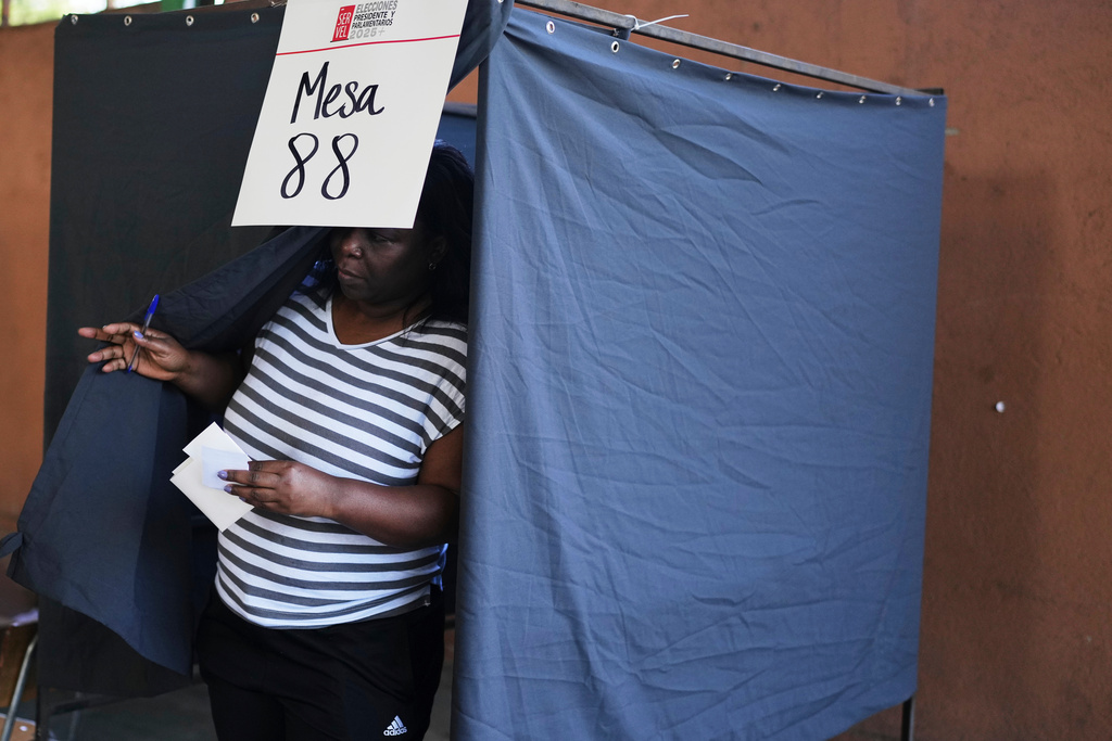 A voter holds her ballot after choosing her preferences during general elections in Santiago, Chile, Sunday, Nov. 16, 2025. (AP Photo/Natacha Pisarenko)