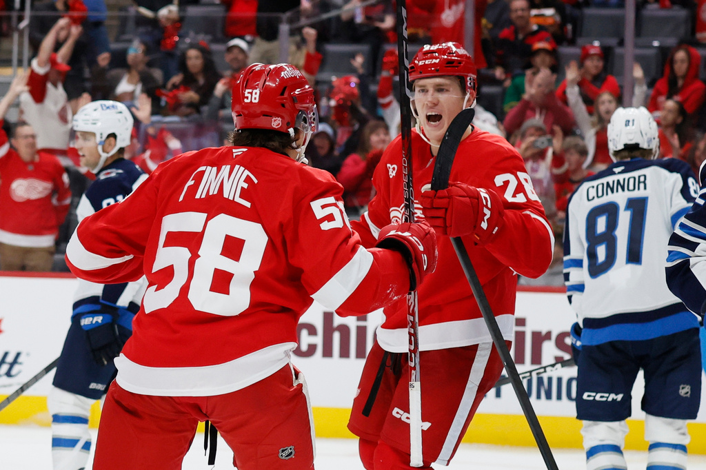 Detroit Red Wings center Emmitt Finnie (58) celebrates after his goal against the Winnipeg Jets with right wing Michael Brandsegg-Nygard (28) during the third period of an NHL hockey game Sunday, Oct. 4, 2026, in Detroit. (AP Photo/Duane Burleson)