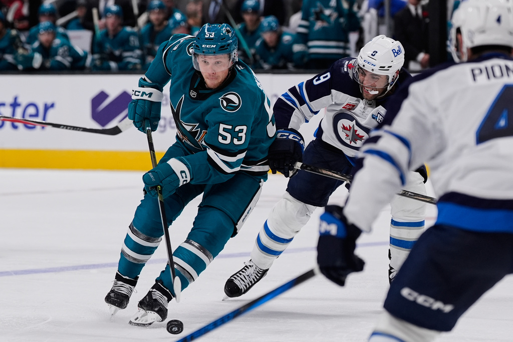 San Jose Sharks left wing Jeff Skinner (53) moves the puck while defended by Winnipeg Jets left wing Alex Iafallo (9) during the third period of an NHL hockey game, Friday, Nov. 7, 2025, in San Jose, Calif. (AP Photo/Godofredo A. Vásquez)