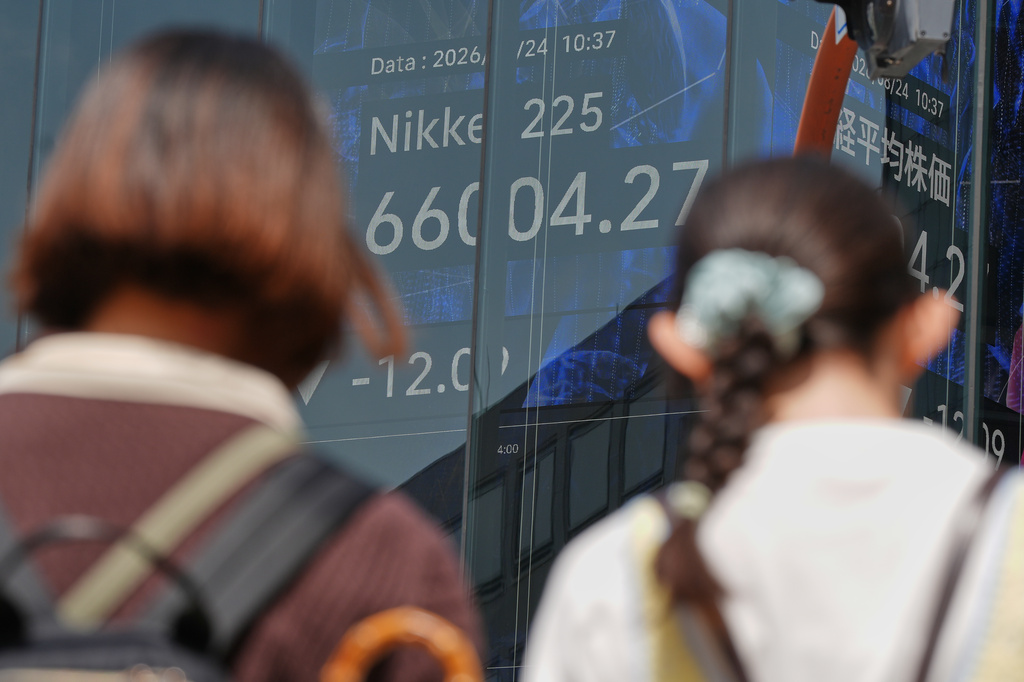 People stand in front of an electronic stock board showing Japan's Nikkei index at a securities firm Monday, Aug. 24, 2026, in Tokyo. (AP Photo/Eugene Hoshiko)