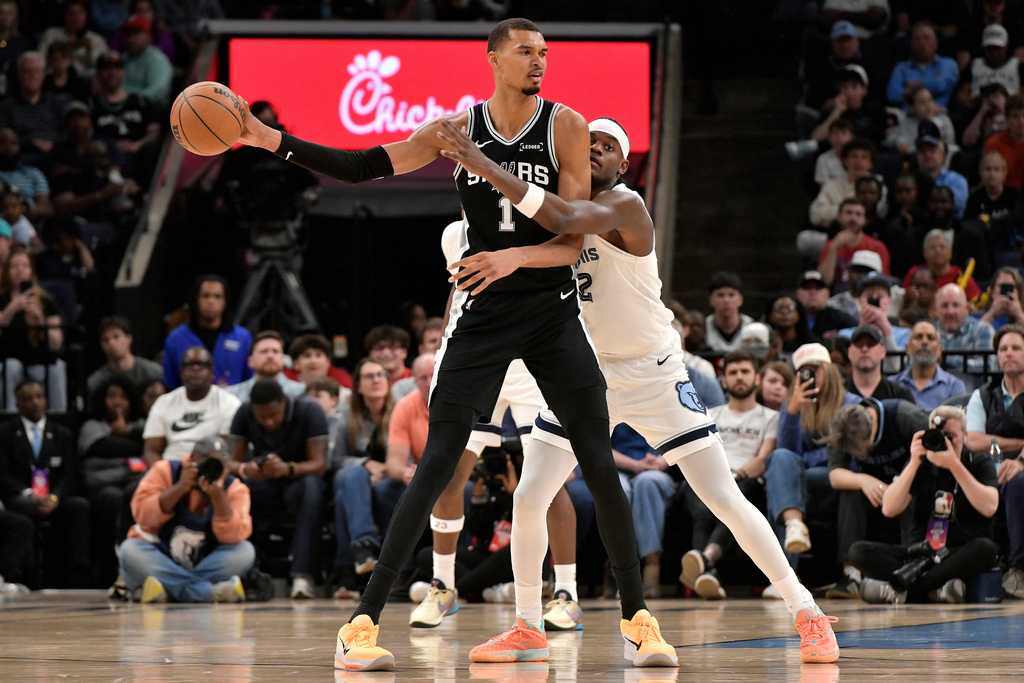 San Antonio Spurs forward Victor Wembanyama (1) handles the ball against Memphis Grizzlies forward Taylor Hendricks (22) in the first half of an NBA basketball game Wednesday, March 25, 2026, in Memphis, Tenn. (AP Photo/Brandon Dill)