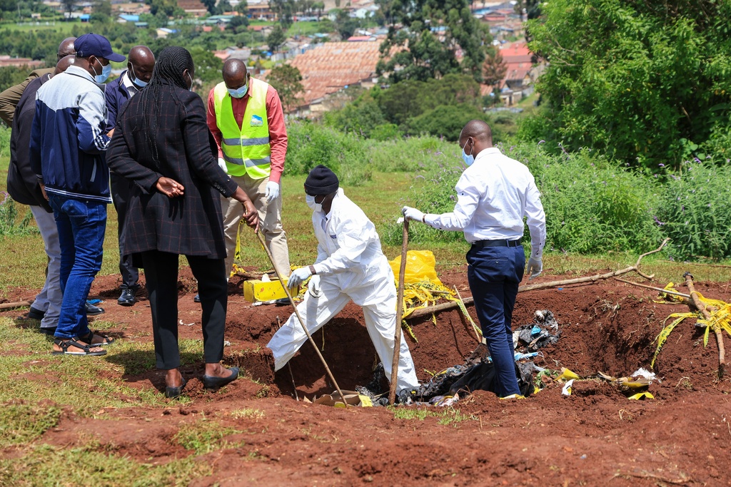 Directorate of Criminal Investigations (DCI) forensic staff inspect the scene of a mass grave where 33 bodies were exhumed at a cemetery in Kericho, Western Kenya Thursday, March 26, 2026. (AP Photo/Andrew Kasuku)