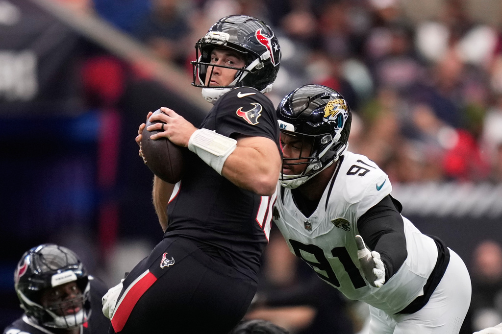 Houston Texans quarterback Davis Mills (10) avoids the sack against Jacksonville Jaguars defensive tackle Arik Armstead (91) during an NFL football game, Sunday, Nov. 9, 2025, in Houston. (AP Photo/Eric Christian Smith)