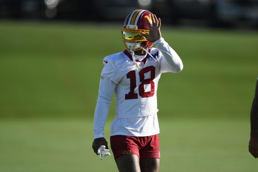 Washington Commanders wide receiver Stefon Diggs waves to fans at the team's NFL football training camp in Ashburn, Va., Friday, Aug. 7, 2026. (AP Photo/Nick Wass)