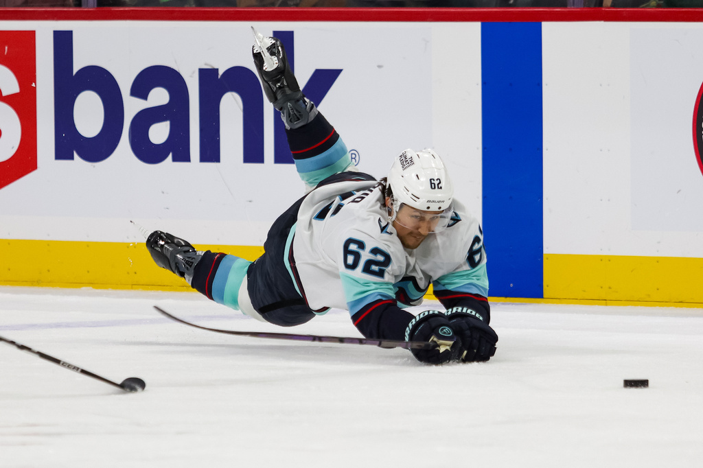 Seattle Kraken's Brandon Montour (62) dives for the puck during the third period of an NHL hockey game Tuesday, April 7, 2026, in St. Paul, Minn. (AP Photo/Lily Dozier)
