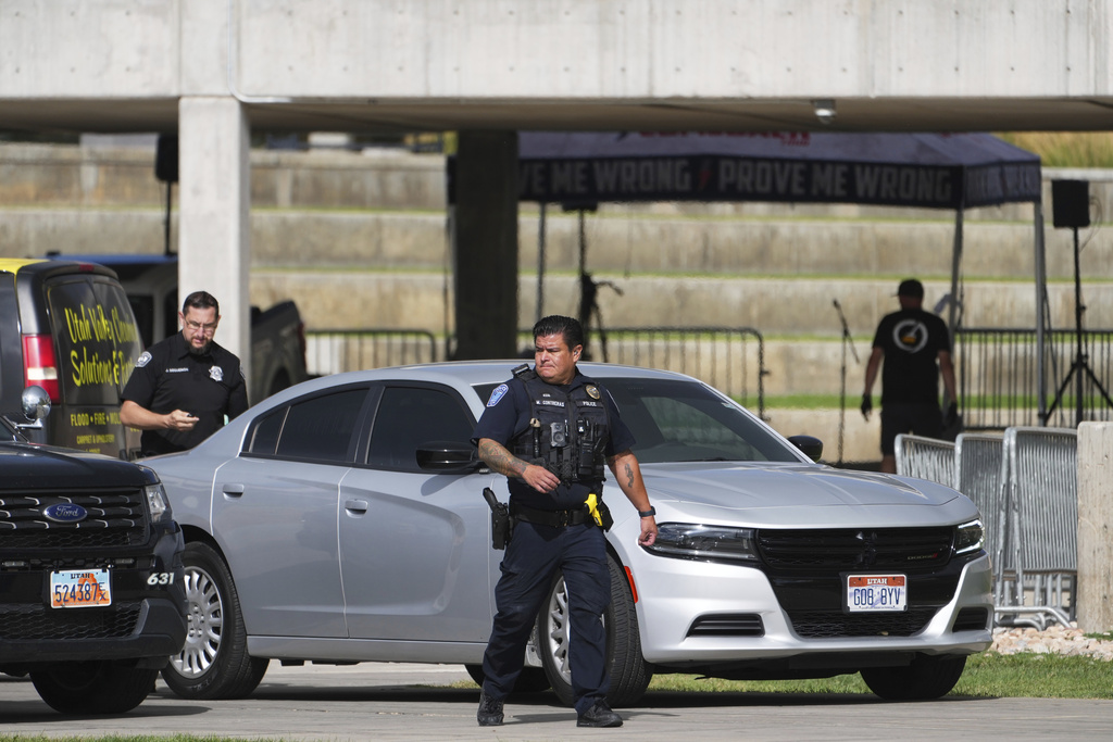 FILE - Police officers look on as a worker cleans up the scene at Utah Valley University on Sept. 12, 2025, in Orem, Utah, after Charlie Kirk was shot and killed. (AP Photo/Lindsey Wasson, File)