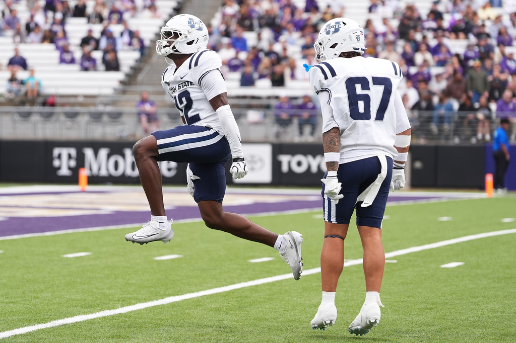 Utah State safety Chika Ebunoha (12) reacts after tackling Washington's Rahshawn Clark for a short gain on a punt return during the second half of an NCAA college football game Saturday, Sept. 12, 2026, in Seattle. (AP Photo/Lindsey Wasson)