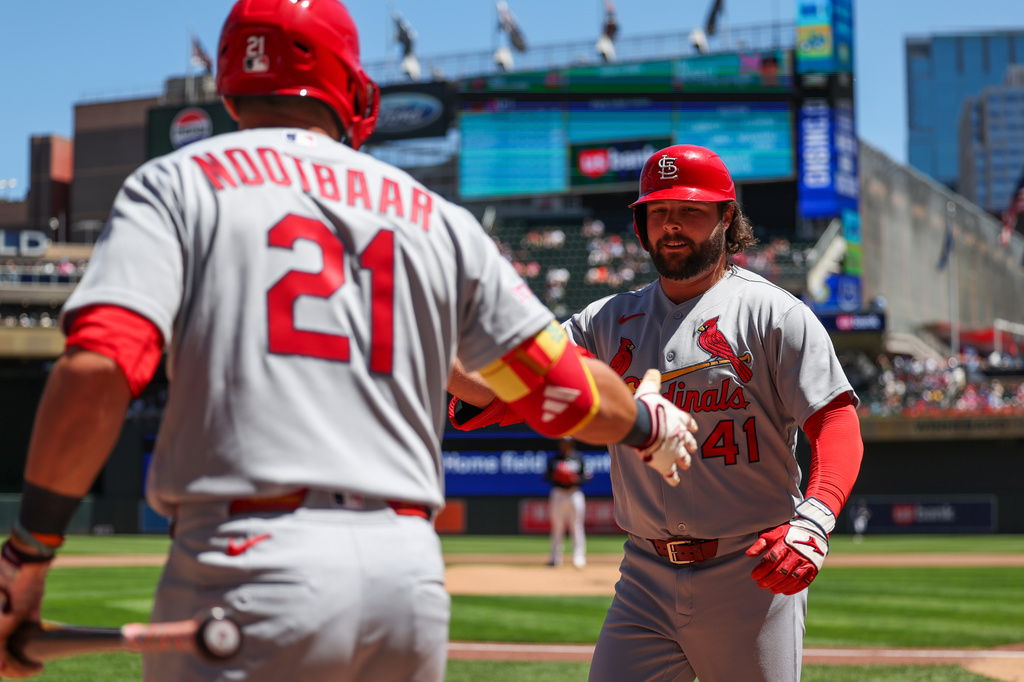 St. Louis Cardinals' Alec Burleson (41) slaps hands with on-deck batter Lars Nootbaar (21) after hitting a home run during fourth inning of a baseball game against the Minnesota Twins, Sunday, June 14, 2026, in Minneapolis. (AP Photo/Ellen Schmidt)