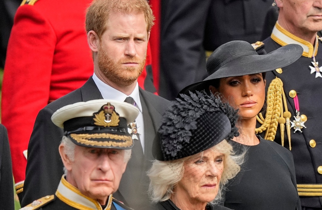 FILE - Britain's King Charles III, from bottom left, Camilla, the Queen Consort, Prince Harry and Meghan, Duchess of Sussex watch as the coffin of Queen Elizabeth II is placed into the hearse following the state funeral service in Westminster Abbey in central London Monday Sept. 19, 2022. (AP Photo/Martin Meissner, Pool, File)