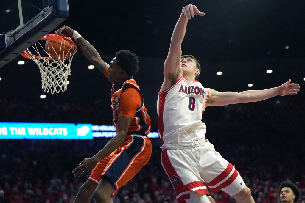 Auburn guard Tahaad Pettiford dunks past Arizona forward Ivan Kharchenkov (8) during the first half of an NCAA college basketball game, Saturday, Dec. 6, 2025, in Tucson, Ariz. (AP Photo/Rick Scuteri)