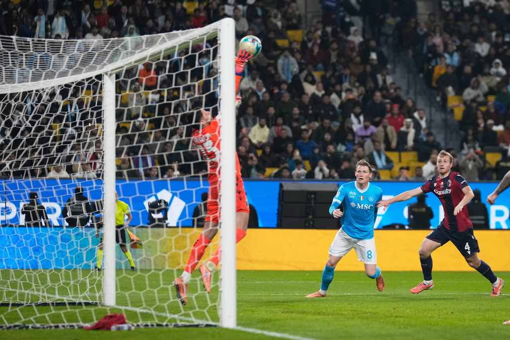 Bologna's goalkeeper Federico Ravaglia, left, saves the ball during the Italian Super Cup final soccer match between Napoli and Bologna in Riyadh, Saudi Arabia, Monday, Dec. 22, 2025. (AP Photo/Altaf Qadri)