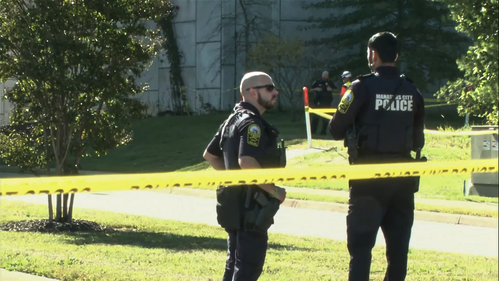 In this image from video provided by WJLA, police officers gather near the scene of a shooting in Manassas, Va., on Wednesday, Sept. 30, 2026. (WJLA via AP)
