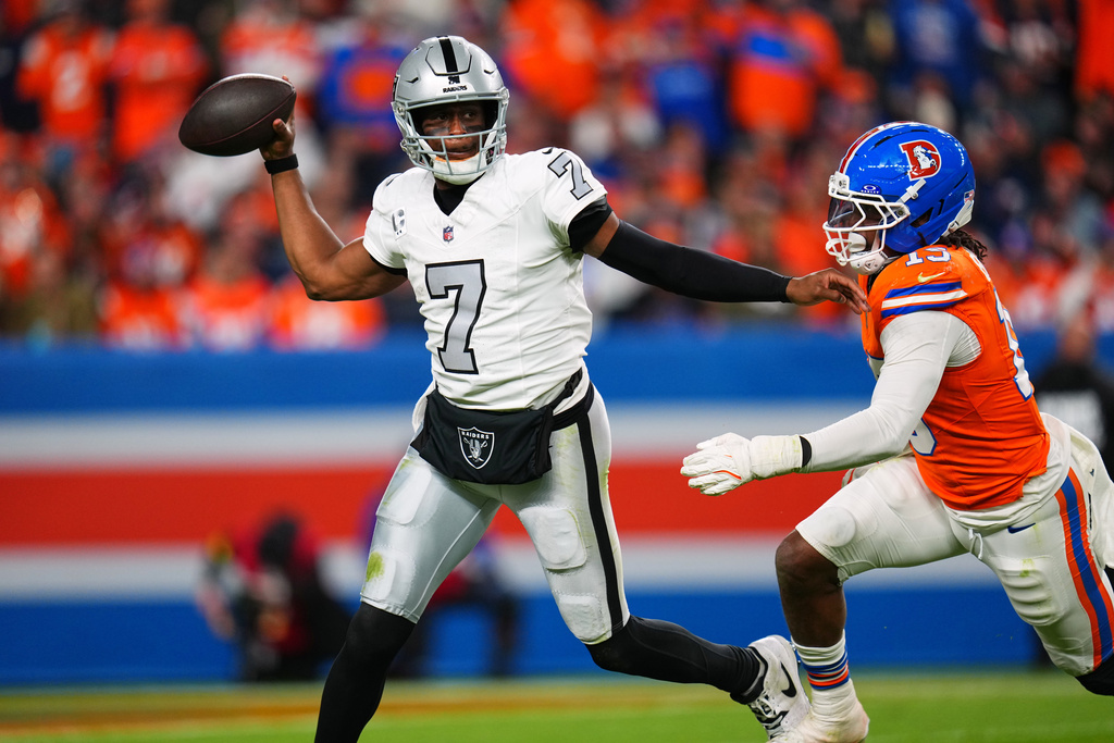 Las Vegas Raiders quarterback Geno Smith (7) throws under pressure from Denver Broncos outside linebacker Nik Bonitto (15) during the second half of an NFL football game Thursday, Nov. 6, 2025, in Denver. (AP Photo/Jack Dempsey)