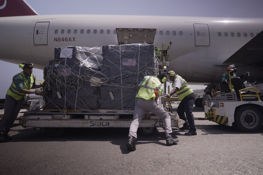 Workers push pallets of medical supplies donated by the U.S. after its arrival at the Simon Bolivar International Airport in Maiquetia, Venezuela, Friday, Feb. 13, 2026. (AP Photo/Juan Arraez)