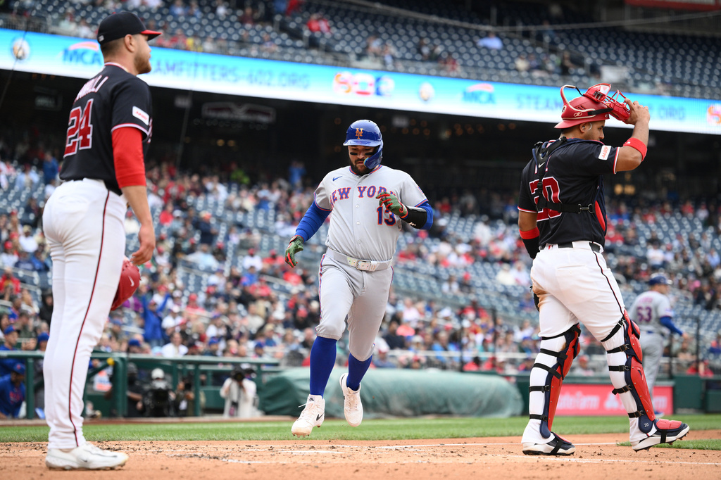 New York Mets' Luis Torrens (13) comes in to score on a single by Bo Bichette during the third inning of a baseball game next to Washington Nationals pitcher Cade Cavalli (24) and catcher Keibert Ruiz (20), Thursday, May 21, 2026, in Washington. (AP Photo/Nick Wass)