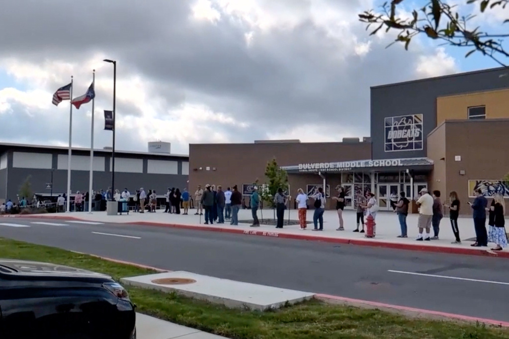 This image taken from video provided by KSAT shows parents waiting in line outside Bulverde Middle School to be reunited with their children after a teacher was shot by a student at Hill Country College Preparatory High School, Monday, March 30, 2026, in Bulverde, Texas. (KSAT via AP)
