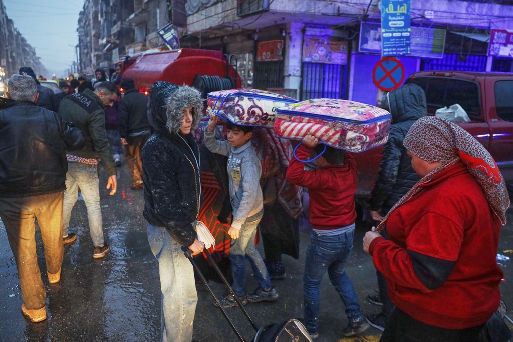 Displaced residents return to a the Achrafieh neighborhood after days of fighting between government forces and Kurdish fighters in the northern city of Aleppo, Syria, Monday, Jan. 12, 2026. (AP Photo/Omar Albam)