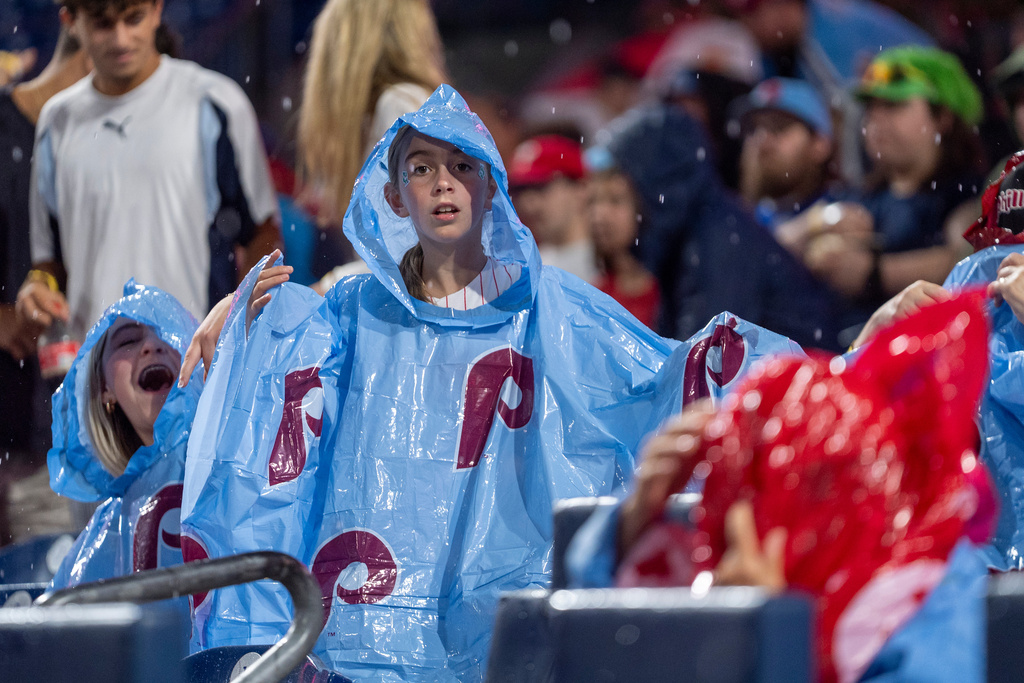Philadelphia Phillies fans dawn their rain gear as the sky open up during the seventh inning of a baseball game against the Maimi Marlins, Thursday, Sept. 25, 2025, in Philadelphia. (AP Photo/Chris Szagola)