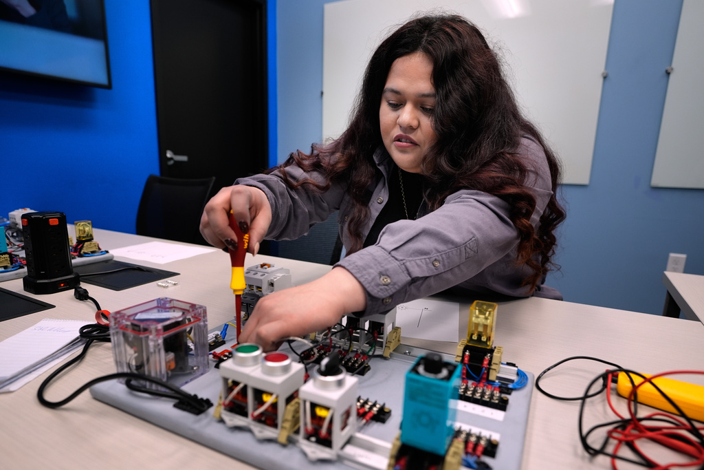 Maintenance technician Liz Cardenas completes a task on an electronics test platform at a training area in a Walmart distribution center Thursday, Sept. 25, 2025, in Bentonville, Ark. (AP Photo/Charlie Riedel)
