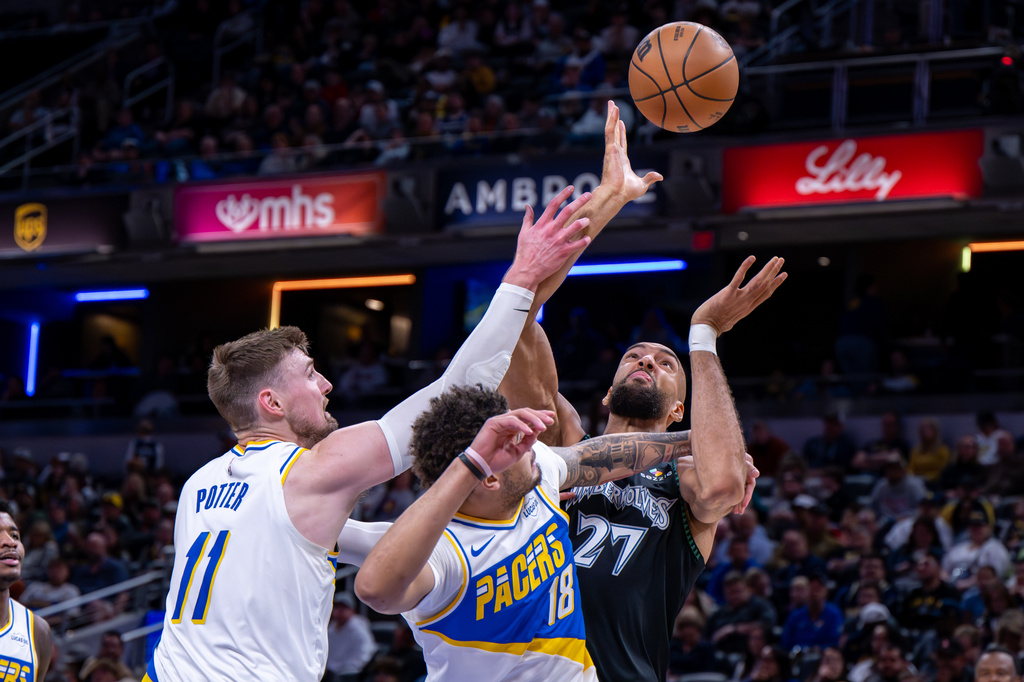 Minnesota Timberwolves center Rudy Gobert (27) battles for a rebound with Indiana Pacers center Micah Potter (11) and forward Jalen Slawson (18) during the first half of an NBA basketball game in Indianapolis, Tuesday, April 7, 2026. (AP Photo/Doug McSchooler)
