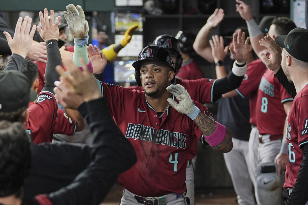 Arizona Diamondbacks' Ketel Marte celebrates in the dugout with the team after hitting a three-run home run in the ninth inning of a baseball game against the Texas Rangers Wednesday, Aug. 13, 2025, in Arlington, Texas. (AP Photo/Tony Gutierrez)