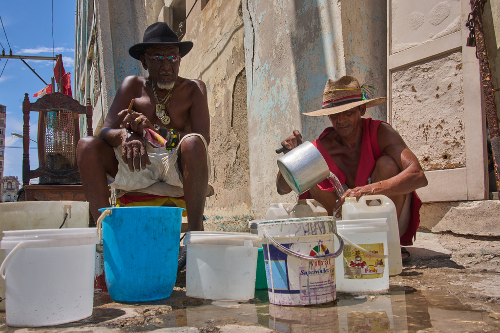 Oscar Joaquín López, left, and his housemate Wilfredo Cisneros Duarte collect water from a street pipe in Havana, Cuba, Monday, Sept. 7, 2026. (AP Photo/Ramon Espinosa)