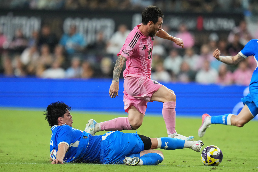 Cruz Azul midfielder Amaury García, left, falls to the field after he goes for the ball against Inter Miami forward Lionel Messi, right, during the first half of the Campeones Cup soccer match, Wednesday, Sept. 16, 2026, in Miami. (AP Photo/Lynne Sladky)