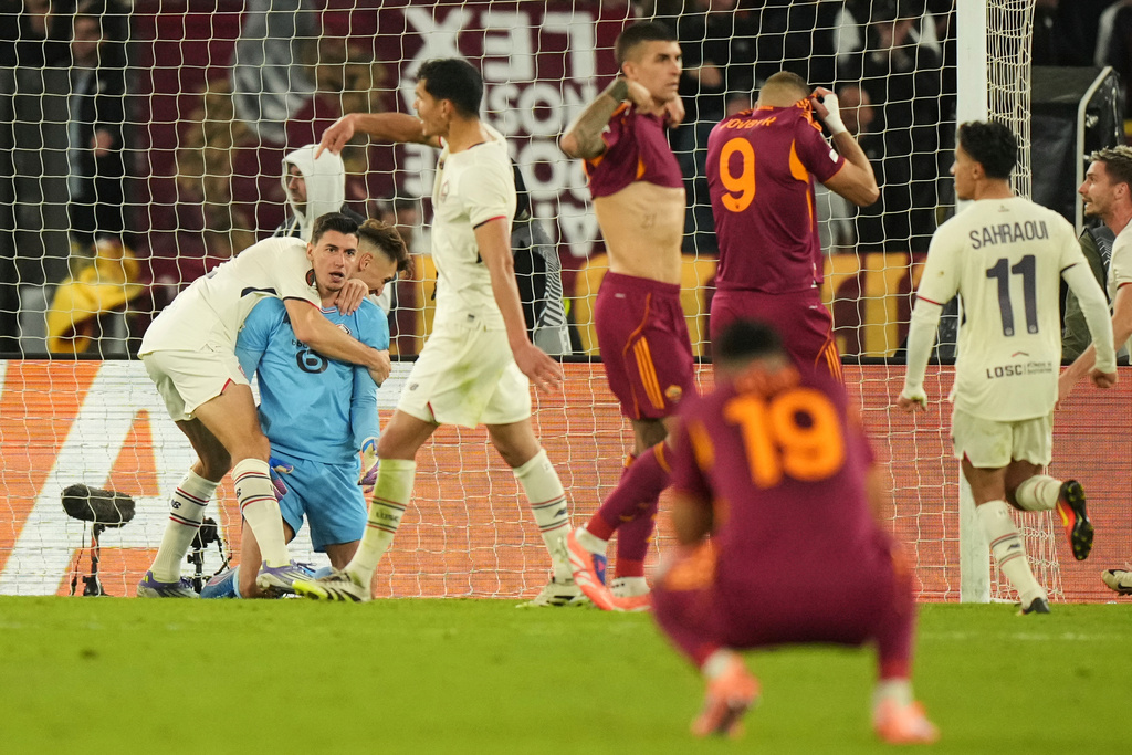 CORRECTS ID TO BERKE ÖZER, NOT MILE SVILAR - Lille goalkeeper Berke Özer celebrates with his teammates aver saving a penalty kicked by Roma's Artem Dovbyk during the Europa League Europa League soccer match between AS Roma and Lille at the Olympic stadium in Rome, Thursday, Oct. 2, 2025. (AP Photo/Andrew Medichini)