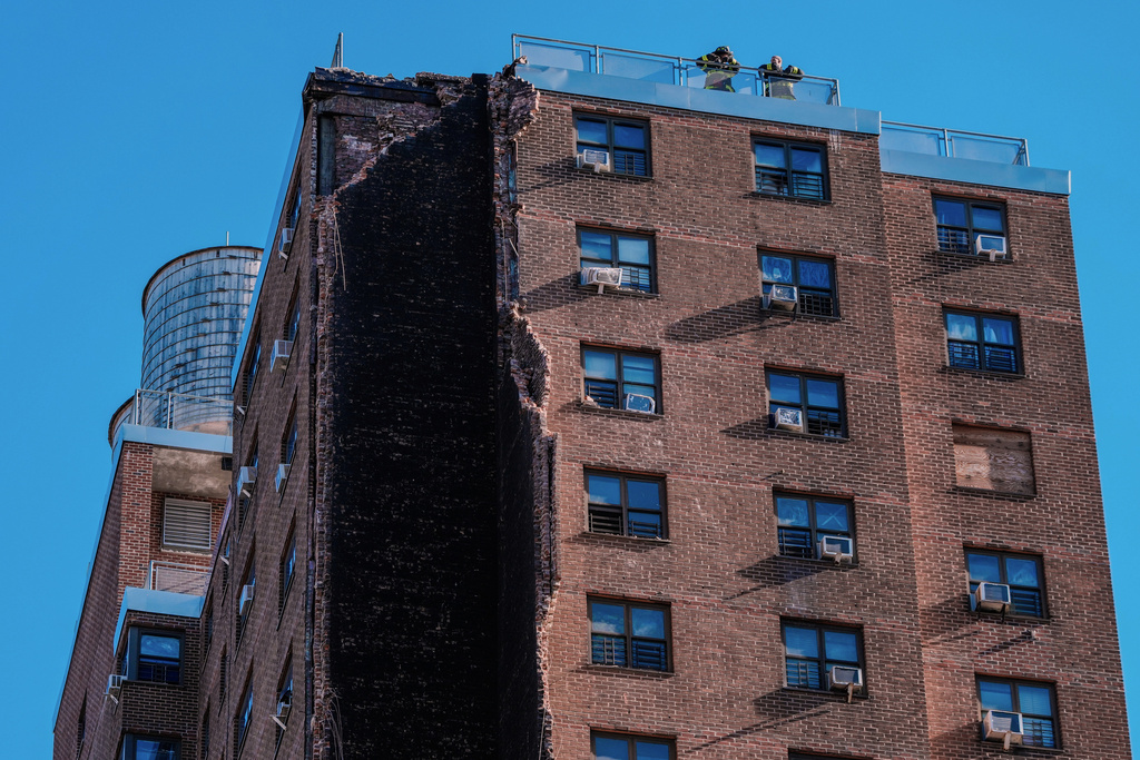 Firefighters stand on the roof of a building that partially collapsed in the Bronx borough of New York, Wednesday, Oct. 1, 2025. (AP Photo/Eduardo Munoz Alvarez)