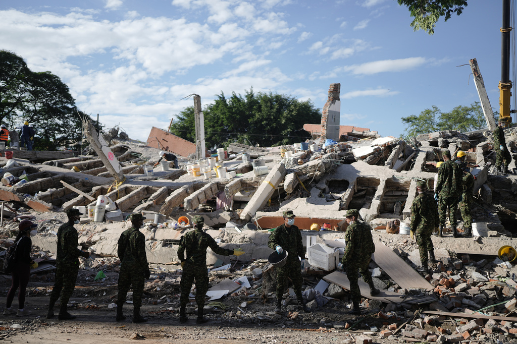 Soldiers clear debris three days after an earthquake struck Cali, Colombia, Thursday, Aug. 13, 2026. (AP Photo/Ivan Valencia)