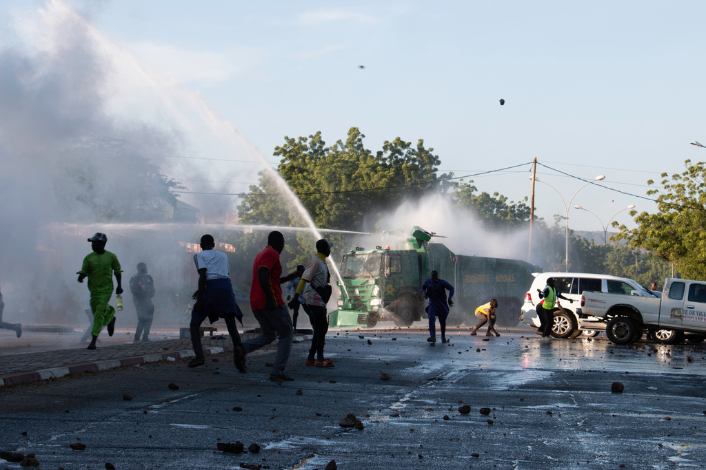 Protesters run as security forces use water cannons to disperse them during clashes in Garoua, Cameroon, Saturday, Oct. 12, 2025 (AP Photo/Welba Yamo Pascal)