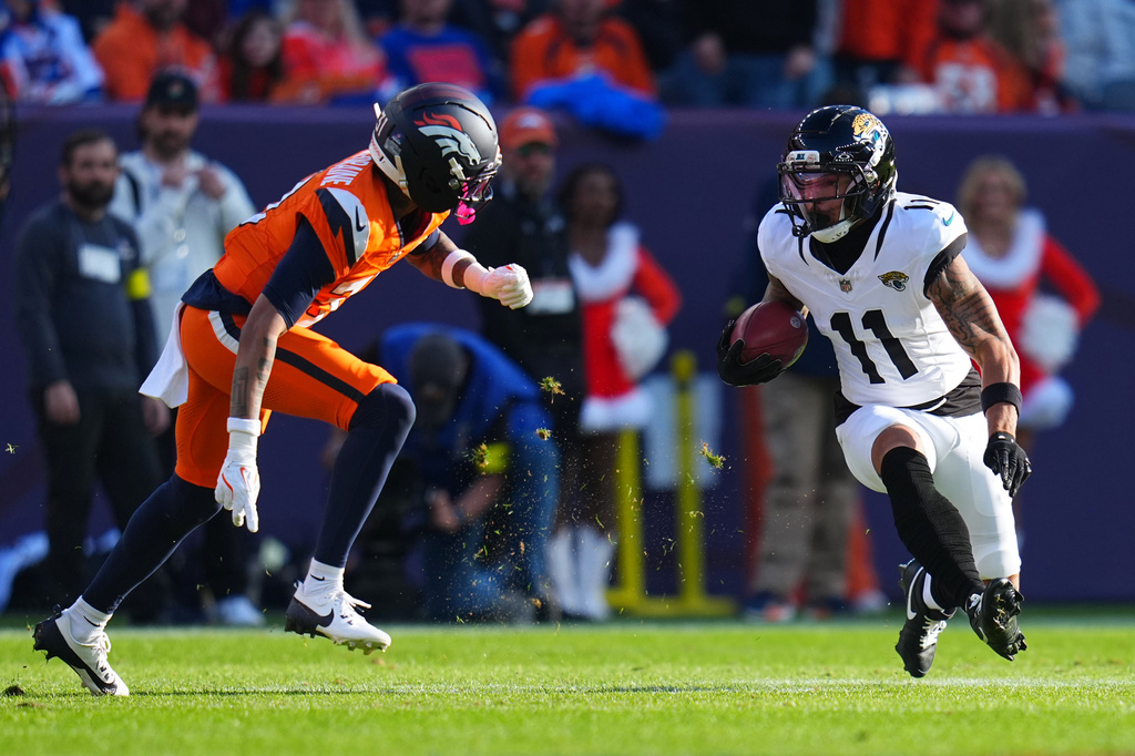 Jacksonville Jaguars wide receiver Parker Washington (11) runs against Denver Broncos cornerback Kris Abrams-Draine, left, during the first half of an NFL football game in Denver, Sunday, Dec. 21, 2025. (AP Photo/Jack Dempsey)