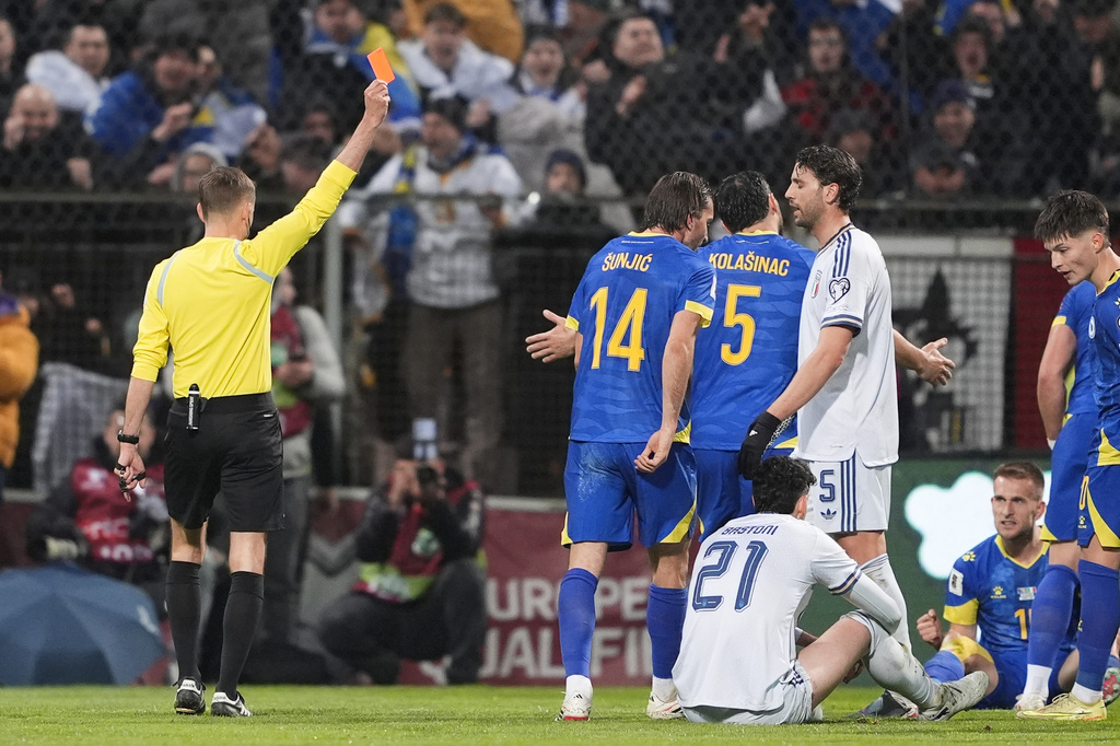 Referee Clement Turpin shows a red card to Italy's Alessandro Bastoni (21) during the World Cup qualifying playoff final soccer match between Bosnia and Italy in Zenica, Bosnia, Tuesday, March 31, 2026. . (Fabio Ferrari/LaPresse via AP)