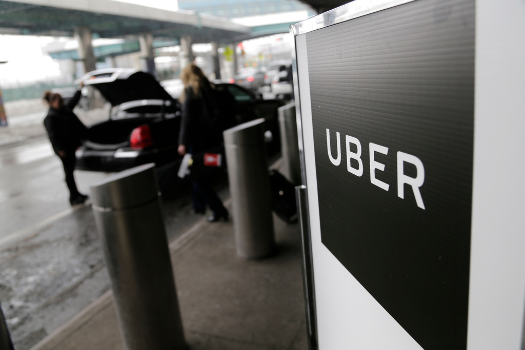 FILE - In this March 15, 2017, file photo, a sign marks a pickup point for the Uber car service at LaGuardia Airport in New York. (AP Photo/Seth Wenig, File)