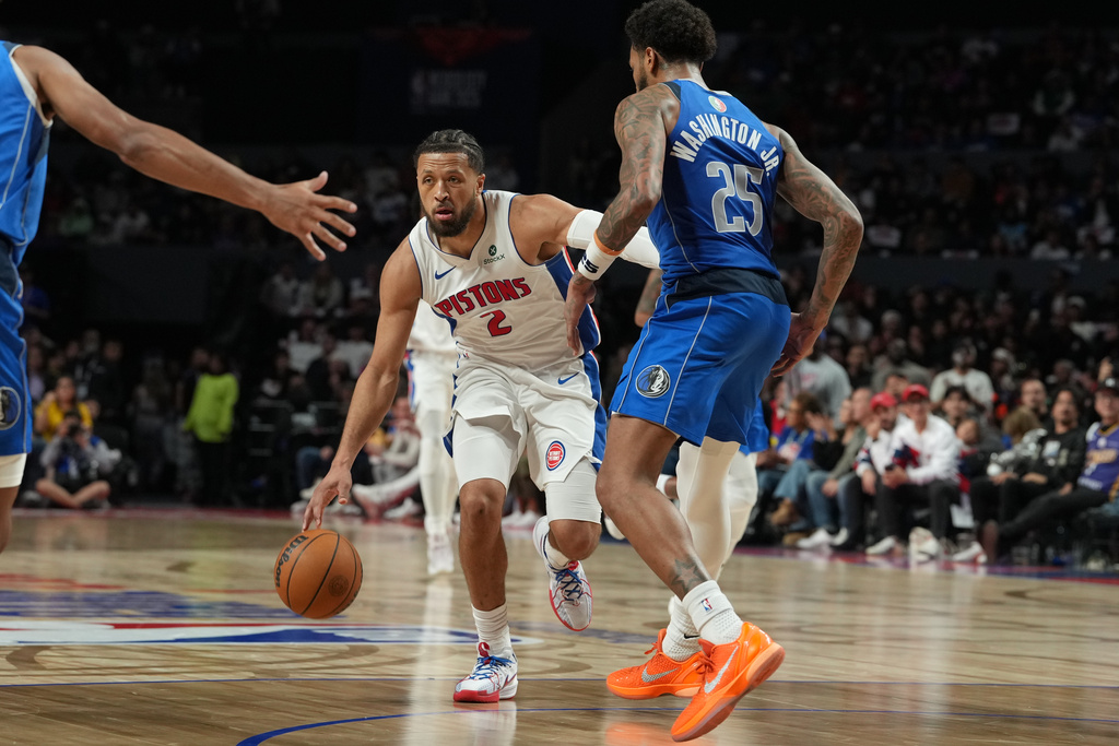Detroit Pistons guard Cade Cunningham, center, goes to the basket against Dallas Mavericks forward P.J. Washington Jr. during the second half of an NBA basketball game in Mexico City, Saturday, Nov. 1, 2025. (AP Photo/Fernando Llano)