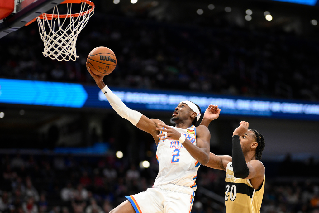 Oklahoma City Thunder guard Shai Gilgeous-Alexander (2) goes to the basket past Washington Wizards center Alex Sarr (20) during the first half of an NBA basketball game, Saturday, March 21, 2026, in Washington. (AP Photo/Nick Wass)
