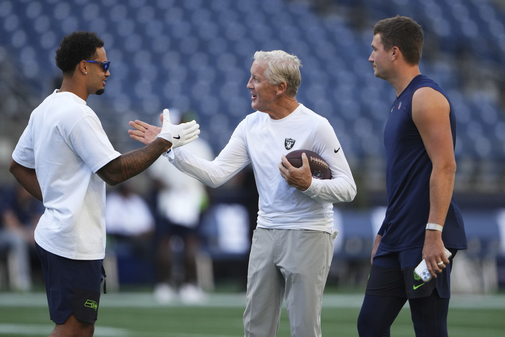 Seattle Seahawks wide receiver Jaxon Smith-Njigba, left, greets Las Vegas Raiders head coach Pete Carroll as Seattle Seahawks quarterback Drew Lock looks on before an NFL preseason football game Thursday, Aug. 7, 2025, in Seattle. (AP Photo/Lindsey Wasson)