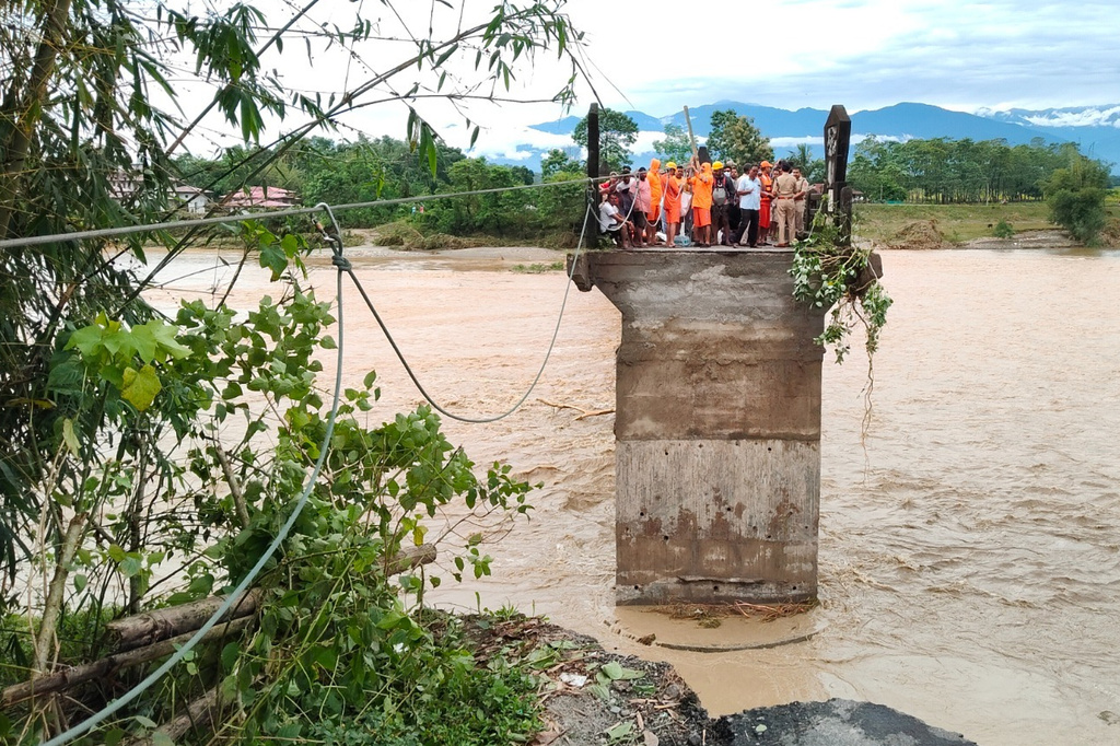 Members of the National Disaster Response Force (NDRF) evacuate stranded people using a temporary zip line laid across a broken bridge after torrential rains trigger multiple landslides near Jalpaiguri in the Indian state of West Bengal, Sunday, Oct. 5, 2025. (The National Disaster Response Force vis AP)