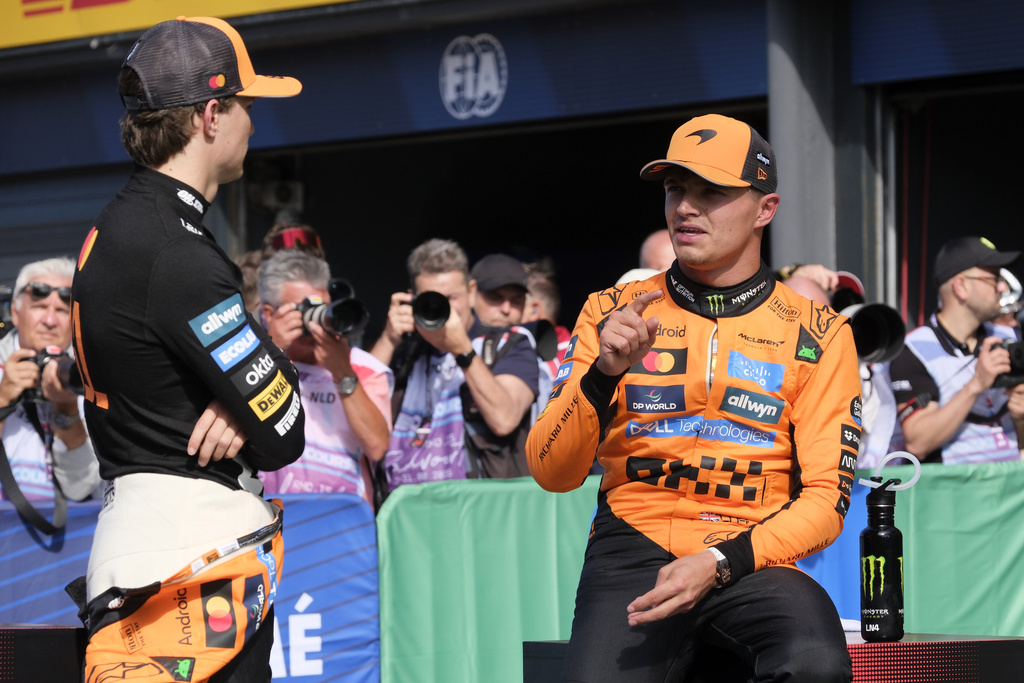 McLaren driver Lando Norris of Britain, right, talks to McLaren driver Oscar Piastri of Australia after the qualifying session ahead of the Formula One Dutch Grand Prix at the Zandvoort racetrack in Zandvoort, Netherlands, Saturday, Aug. 30, 2025. (AP Photo/Patrick Post)
