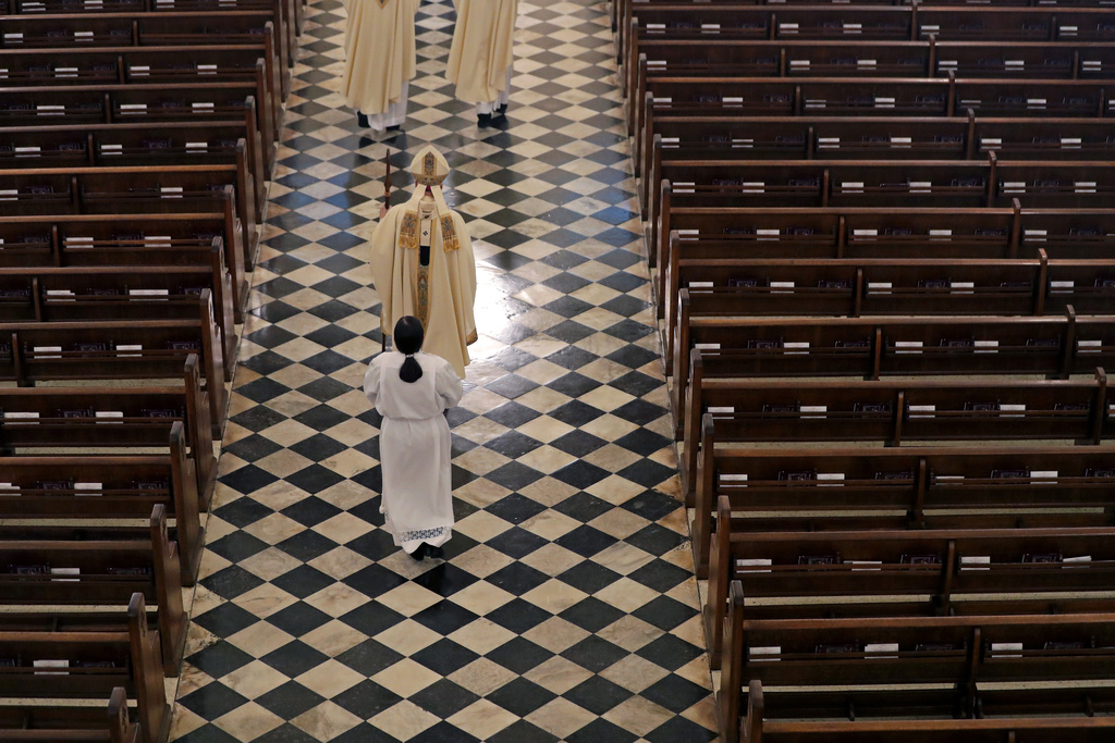 FILE - Archbishop Gregory Aymond conducts the procession to lead a live streamed Easter Mass in St. Louis Cathedral in New Orleans, April 12, 2020. (AP Photo/Gerald Herbert, File)