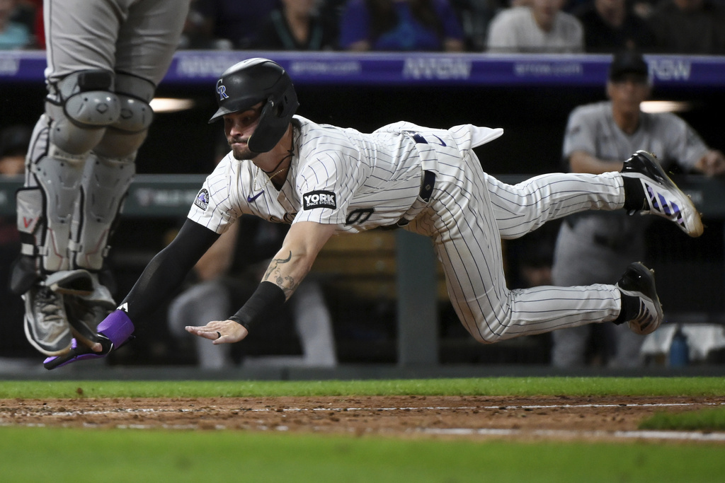 Colorado Rockies' Brenton Doyle slides safely home in the eighth inning of a baseball game against the Arizona Diamondbacks Saturday, Aug. 16, 2025, in Denver. (AP Photo/Geneva Heffernan)