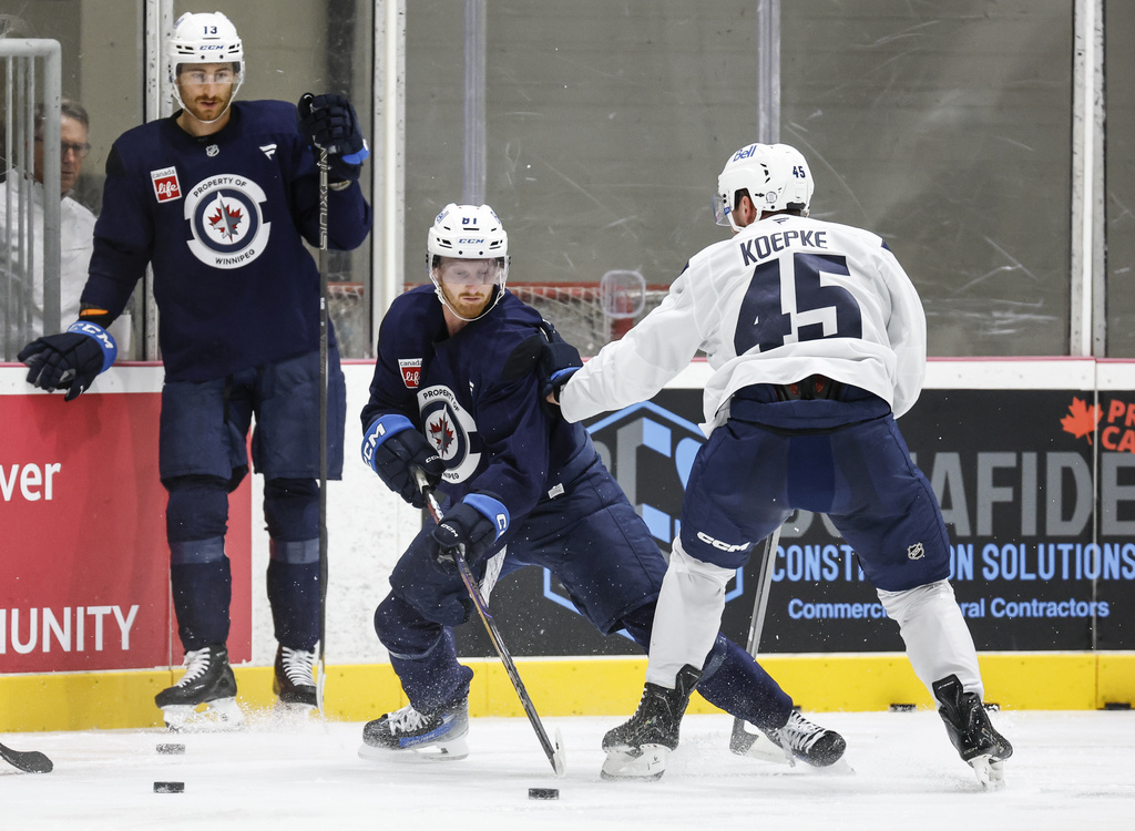 Winnipeg Jets' Gabriel Vilardi (13) looks on as Kyle Connor (81) and Cole Koepke (45) battle in the corner during NHL hockey training camp in Winnipeg, Manitoba, Thursday, Sept. 18, 2025. (John Woods/The Canadian Press via AP)