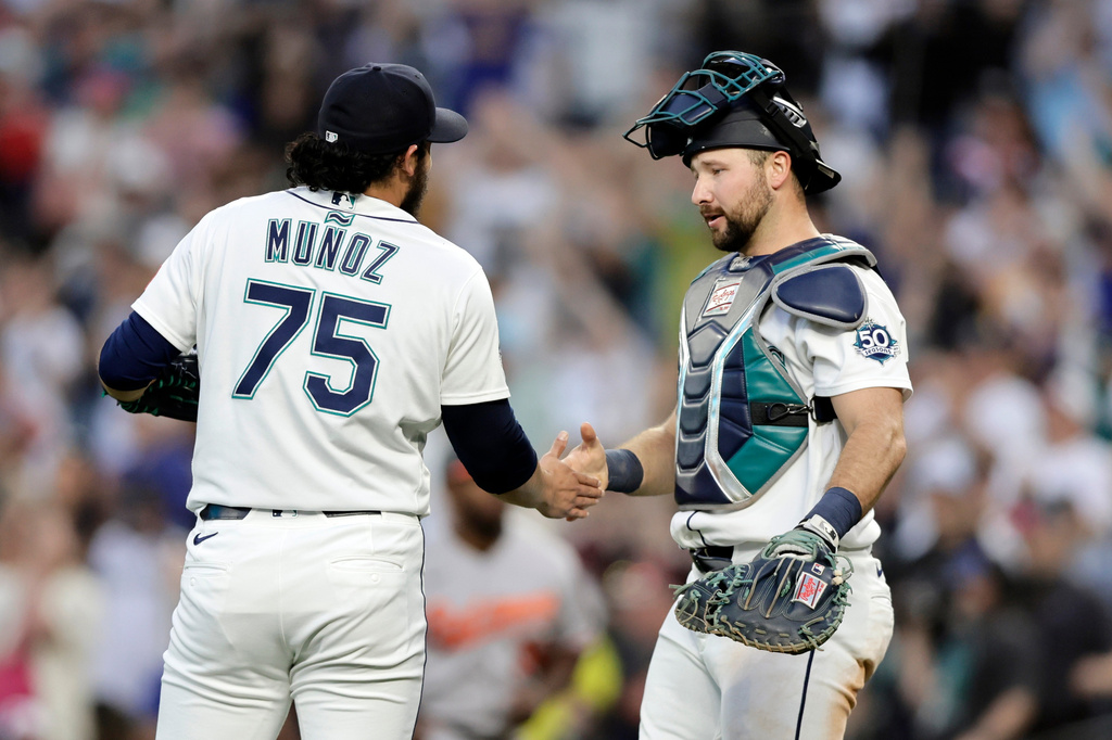 Seattle Mariners pitcher Andrés Muñoz shakes hands with catcher Cal Raleigh after their win over the Baltimore Orioles in a baseball game, Tuesday, June 16, 2026, in Seattle. (AP Photo/John Froschauer)