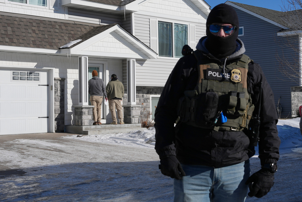 Federal agents knock on a door of a residence on Wednesday, Jan. 28, 2026, in Blaine, Minn. (AP Photo/Adam Gray)